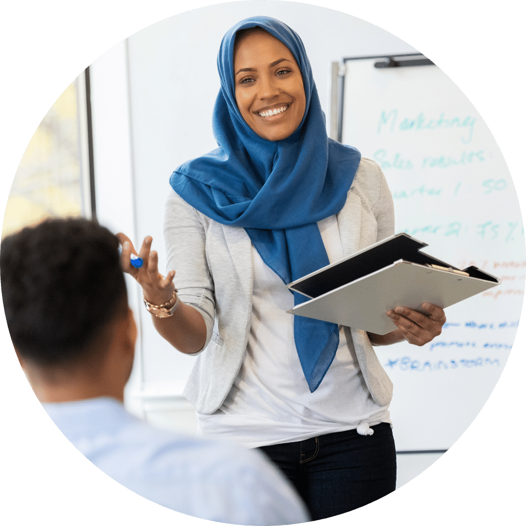 A woman wearing hijab, teaching in a classroom