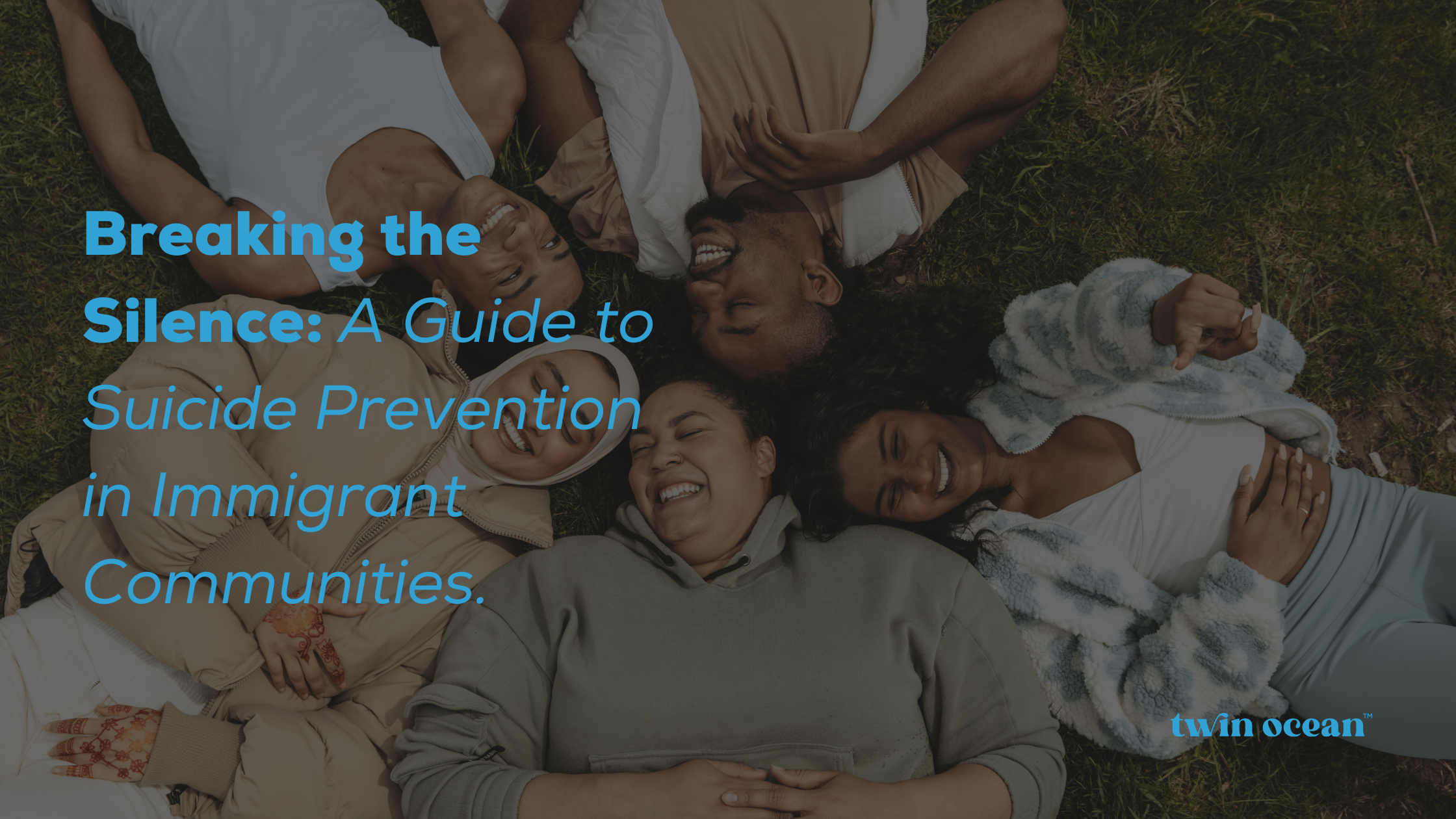 A high-angle view of a diverse group of five smiling friends lying in a circle on the grass with their heads together, sharing a joyful moment. A blue text overlay reads: "Breaking the Silence: A Guide to Suicide Prevention in Immigrant Communities." The twin ocean logo is in the bottom right.