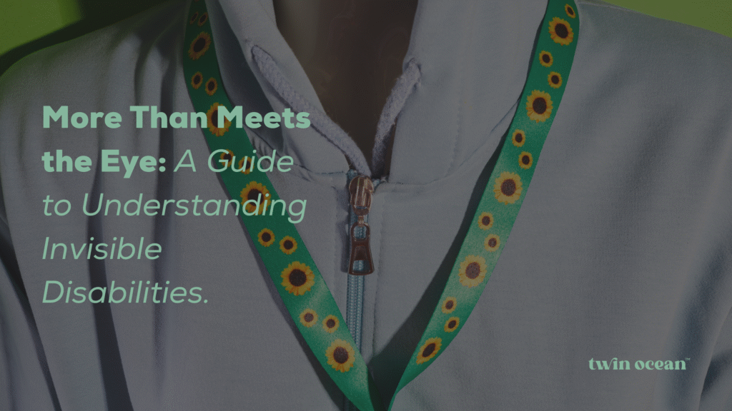 A close-up of a person wearing a white hoodie and a sunflower lanyard, representing an article about understanding invisible disabilities. Text overlay reads: "More Than Meets the Eye: A Guide to Understanding Invisible Disabilities." The twin ocean logo is in the bottom right corner.
